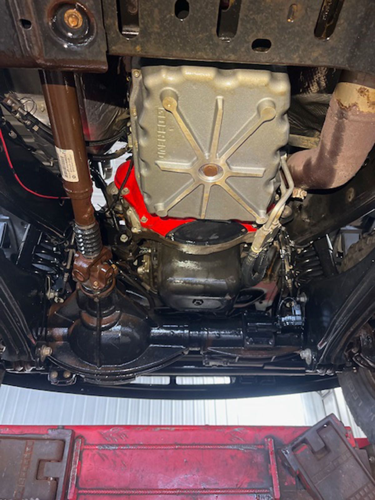 A close-up of the underside of a car with a red engine
