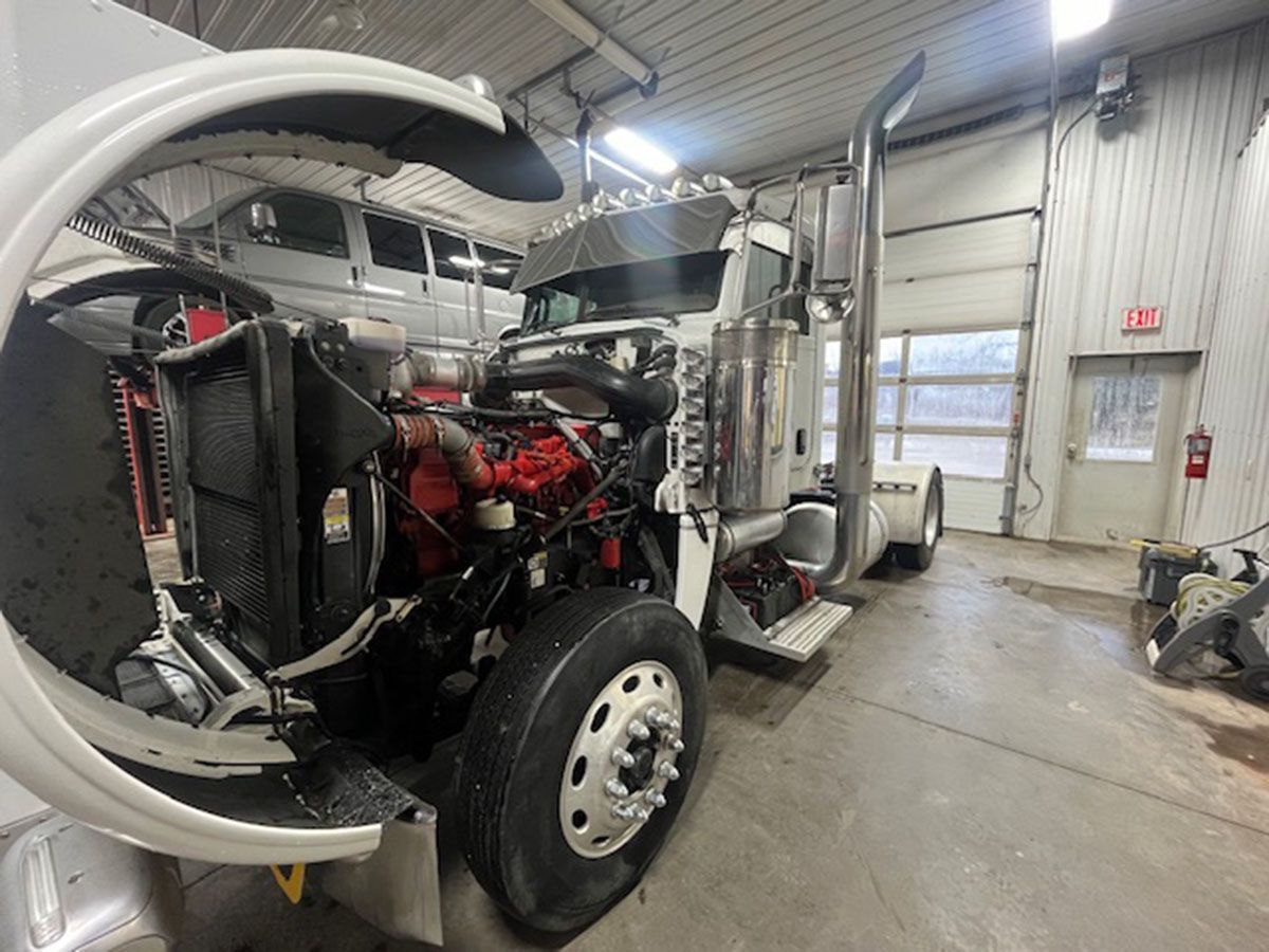 A semi-truck is being worked on in a garage