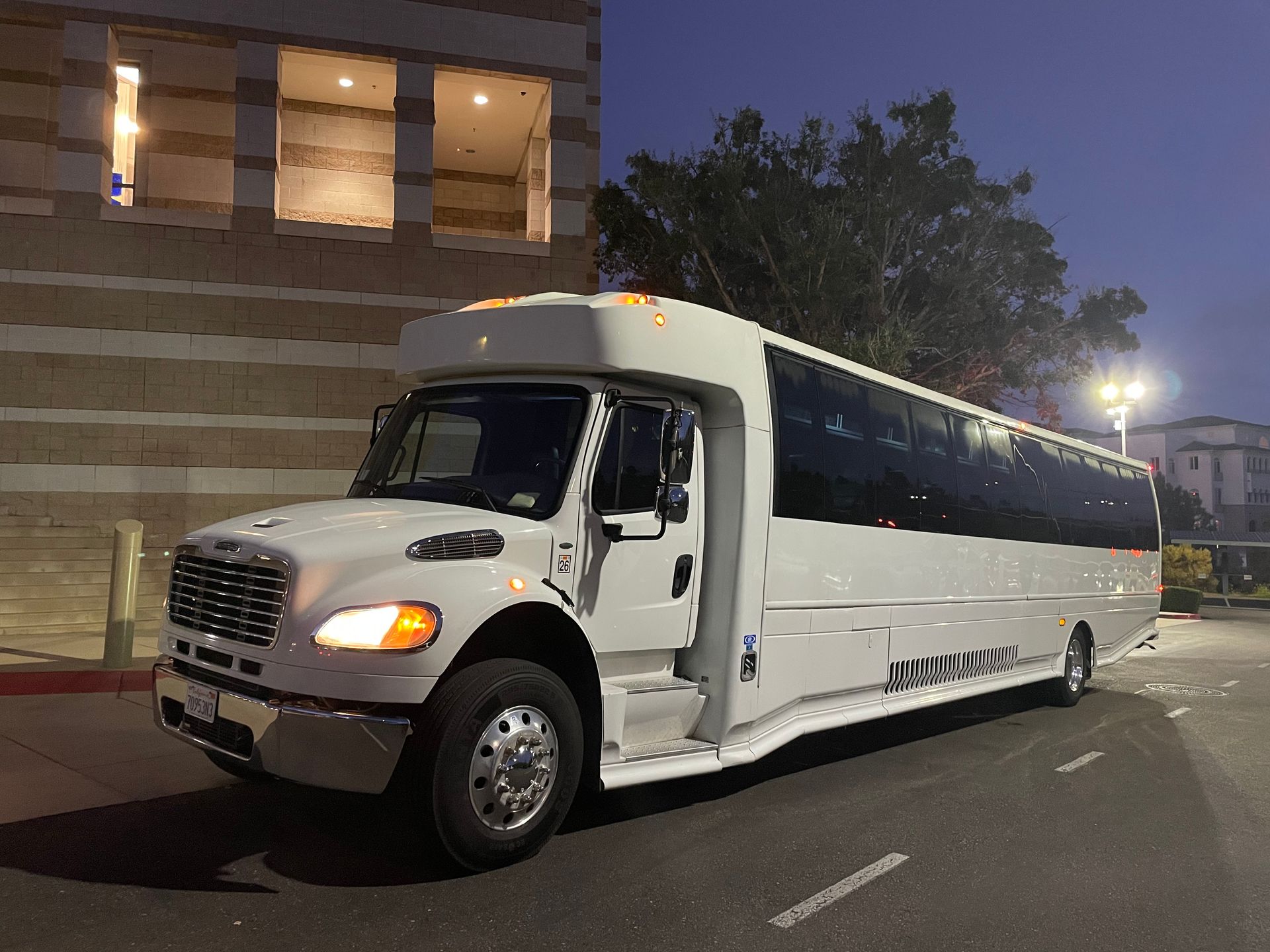 A white bus is driving down a country road.