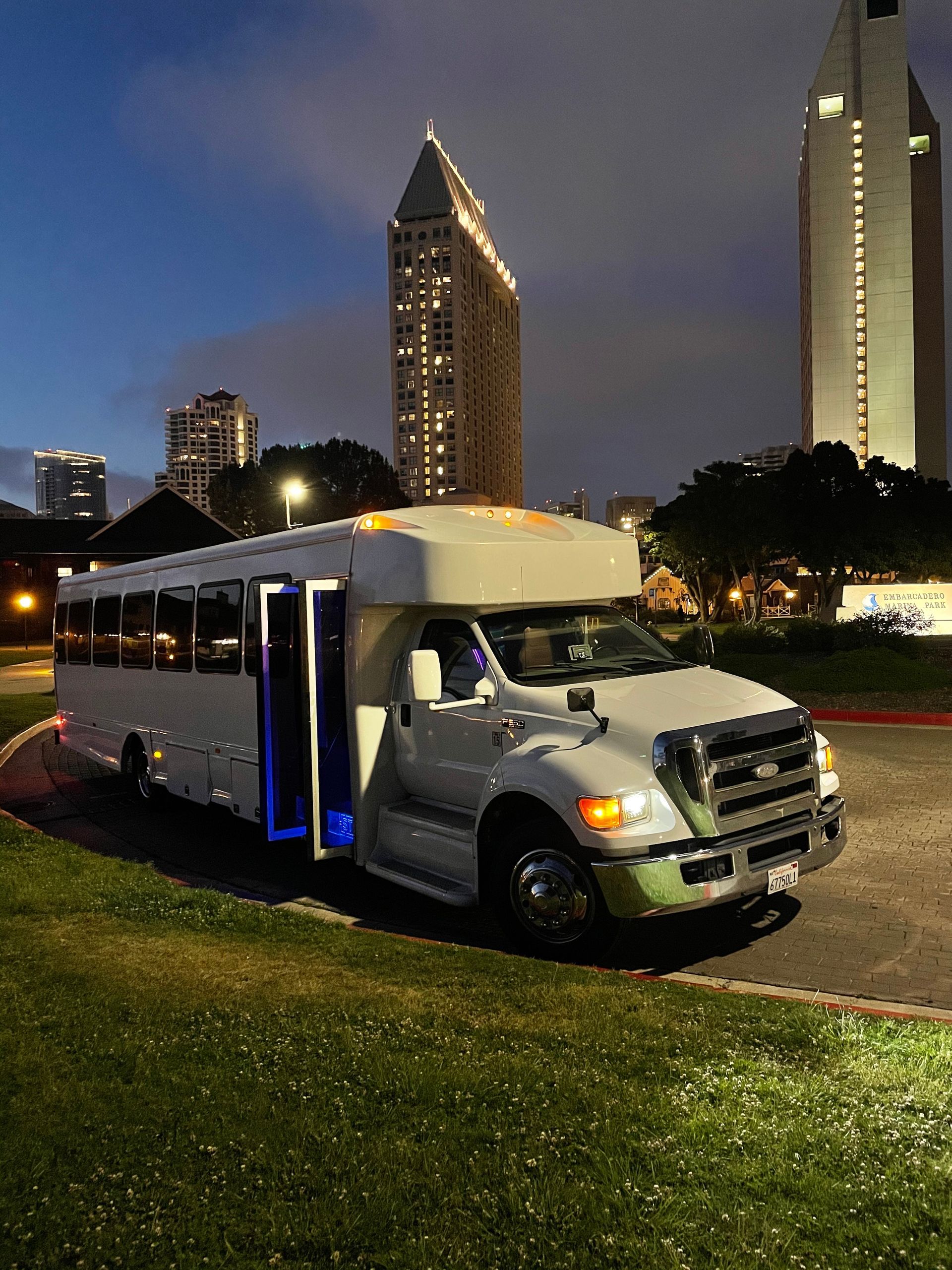 A white bus is parked in front of a Dave & buster 's restaurant.