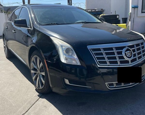 A black Cadillac is parked in a parking lot