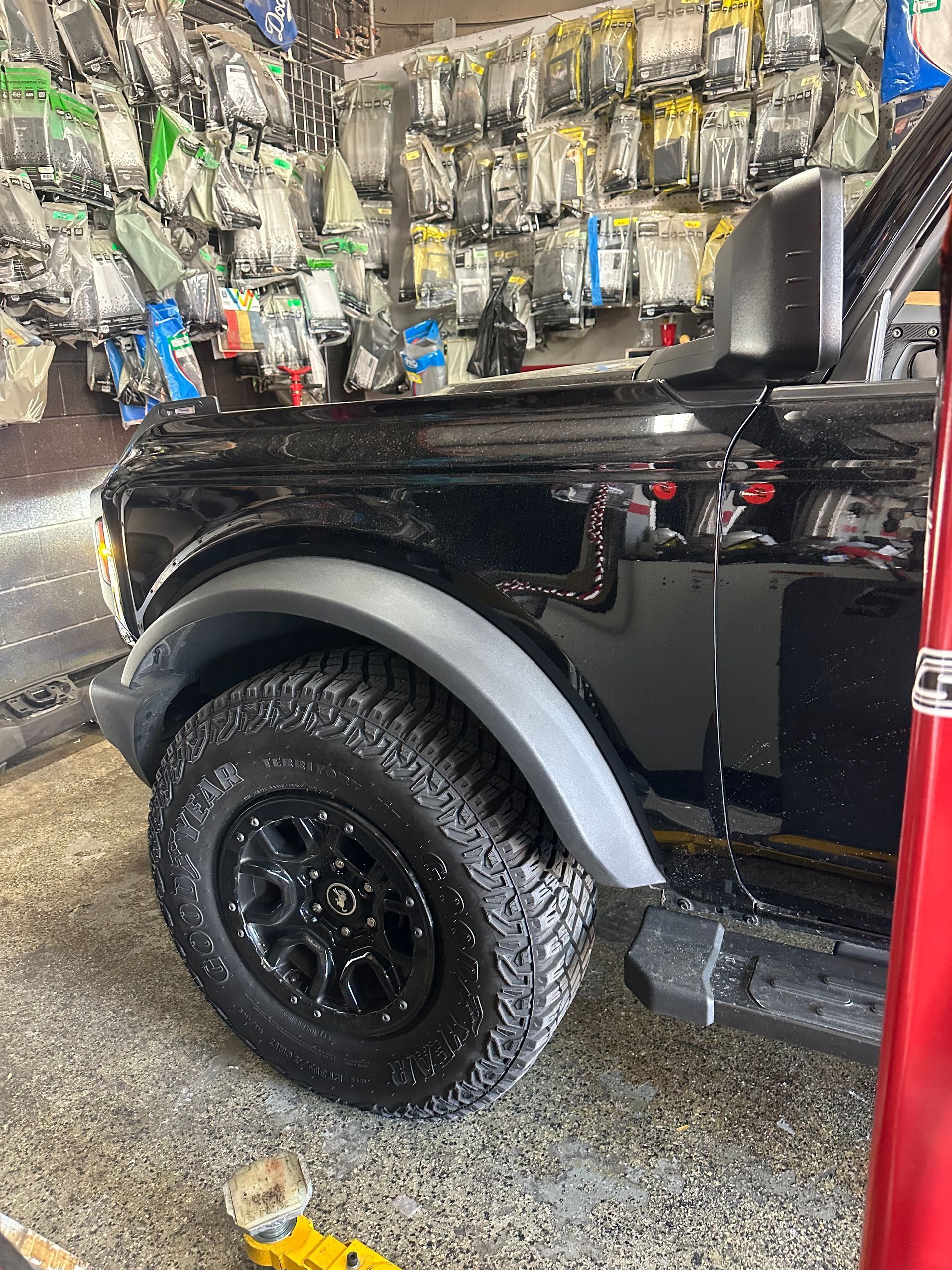 A black ford bronco is parked in a garage next to a lifesaver sign.
