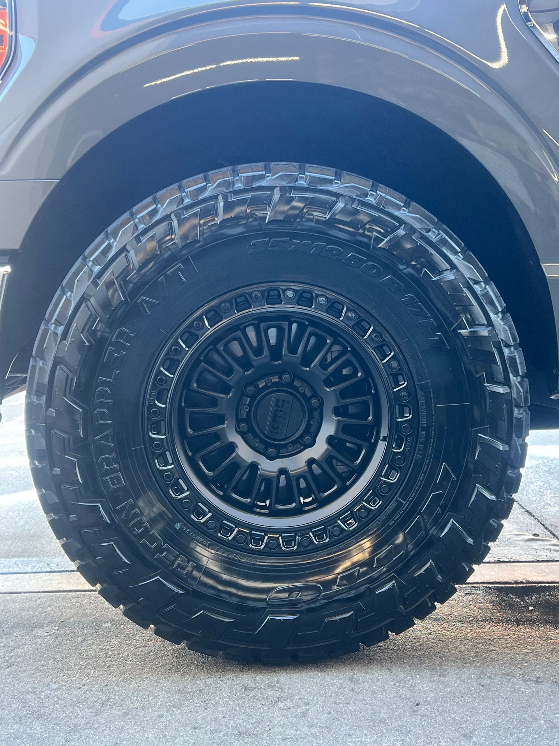 Black truck tire with a black rim.
