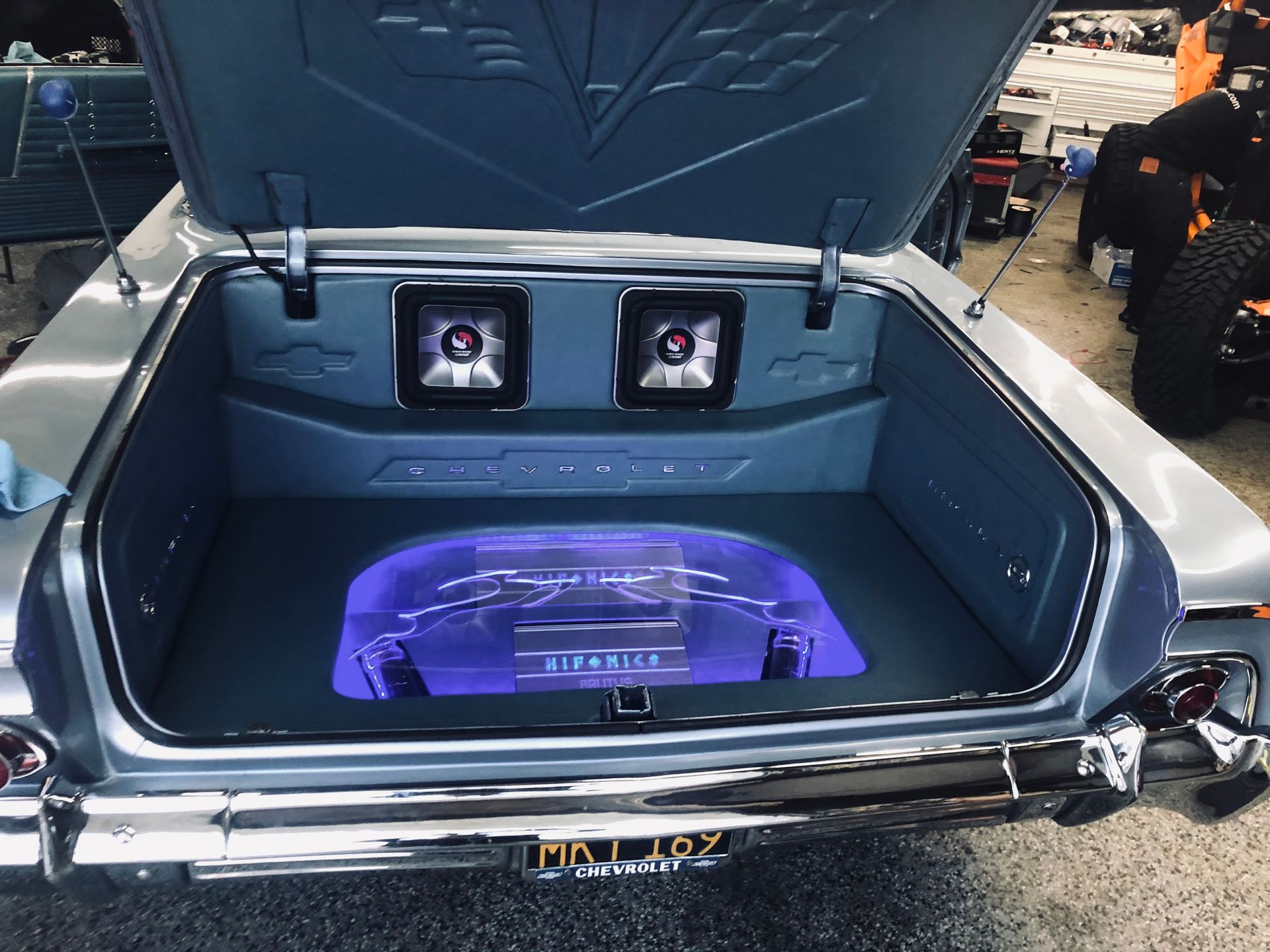 The trunk of a car with a purple speaker in it