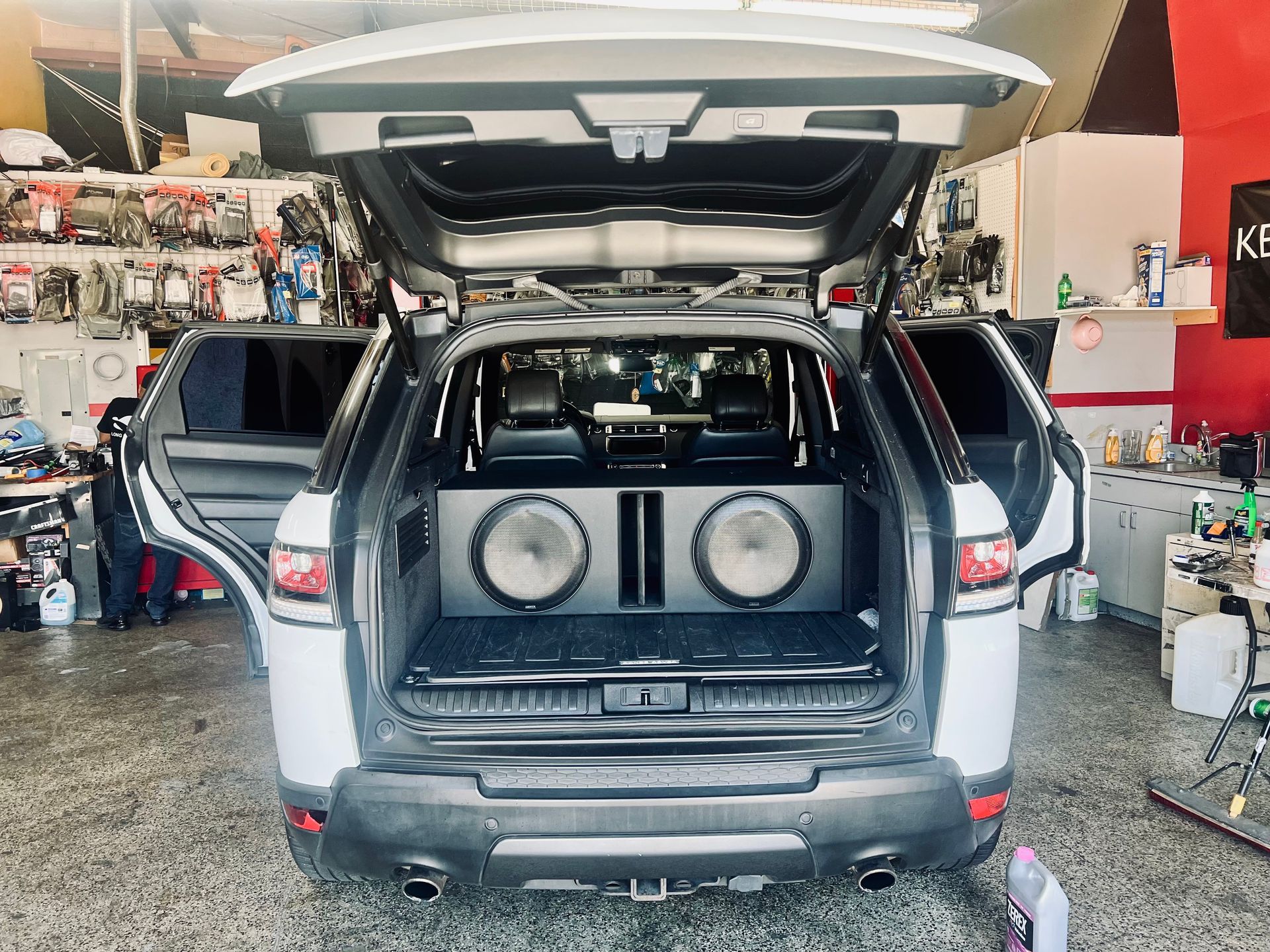 A white suv with the trunk open and speakers in the back.