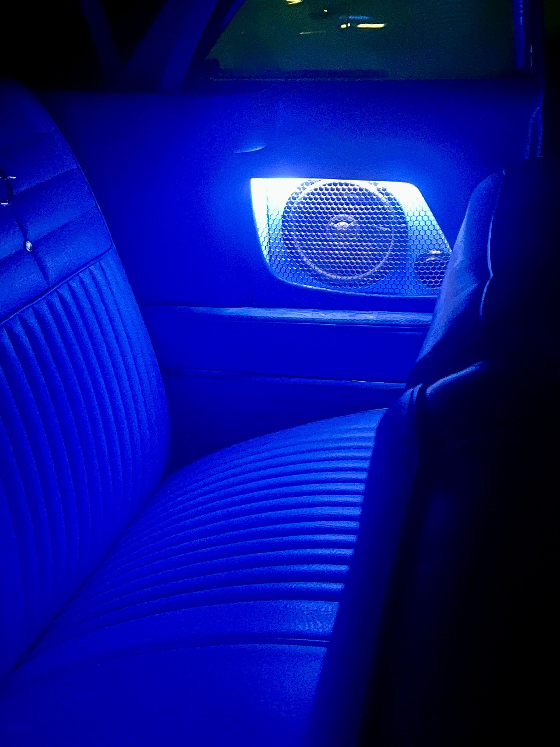 The back seat of a car is lit up with blue lights.