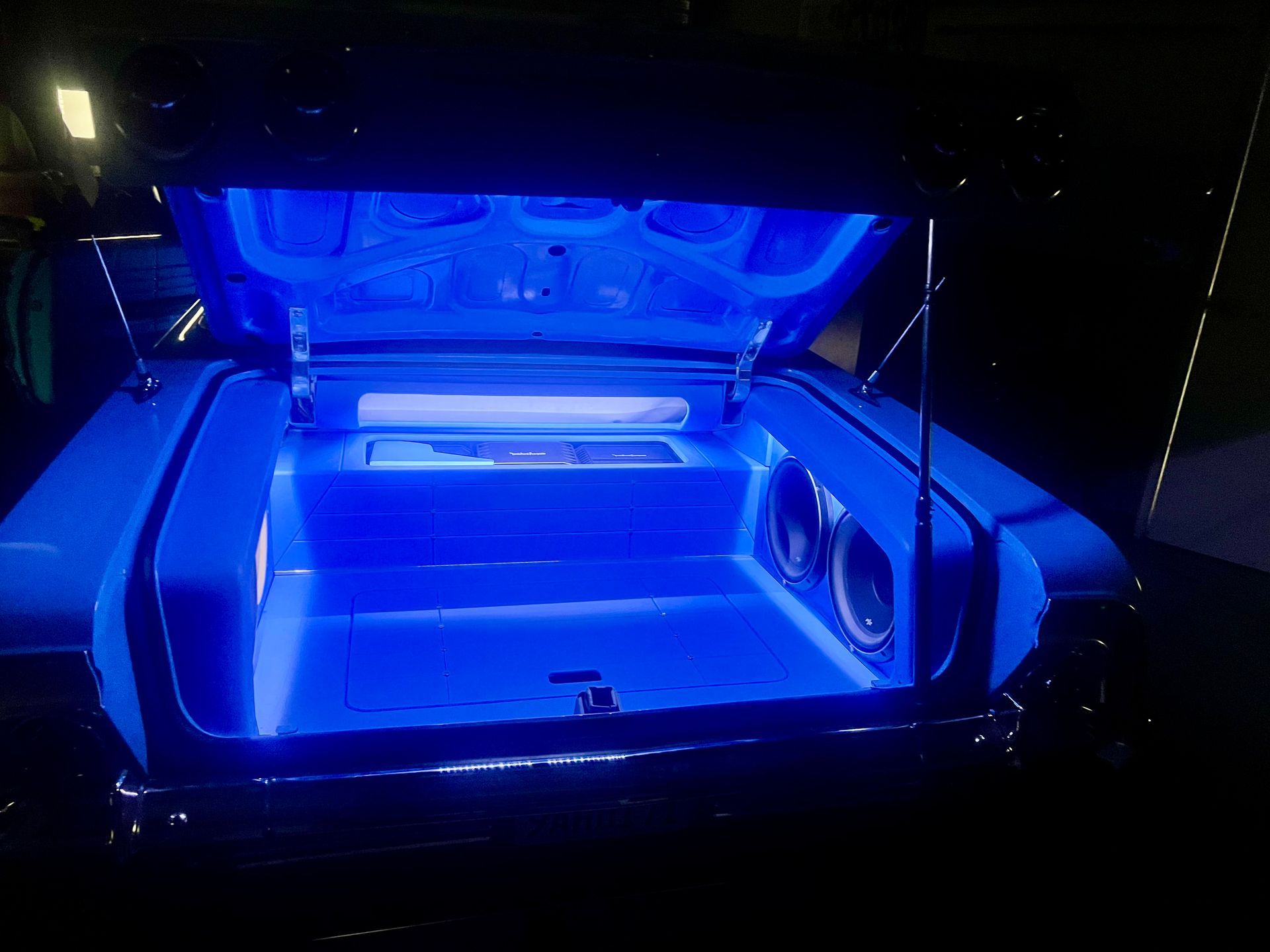 The trunk of a car is lit up with blue lights