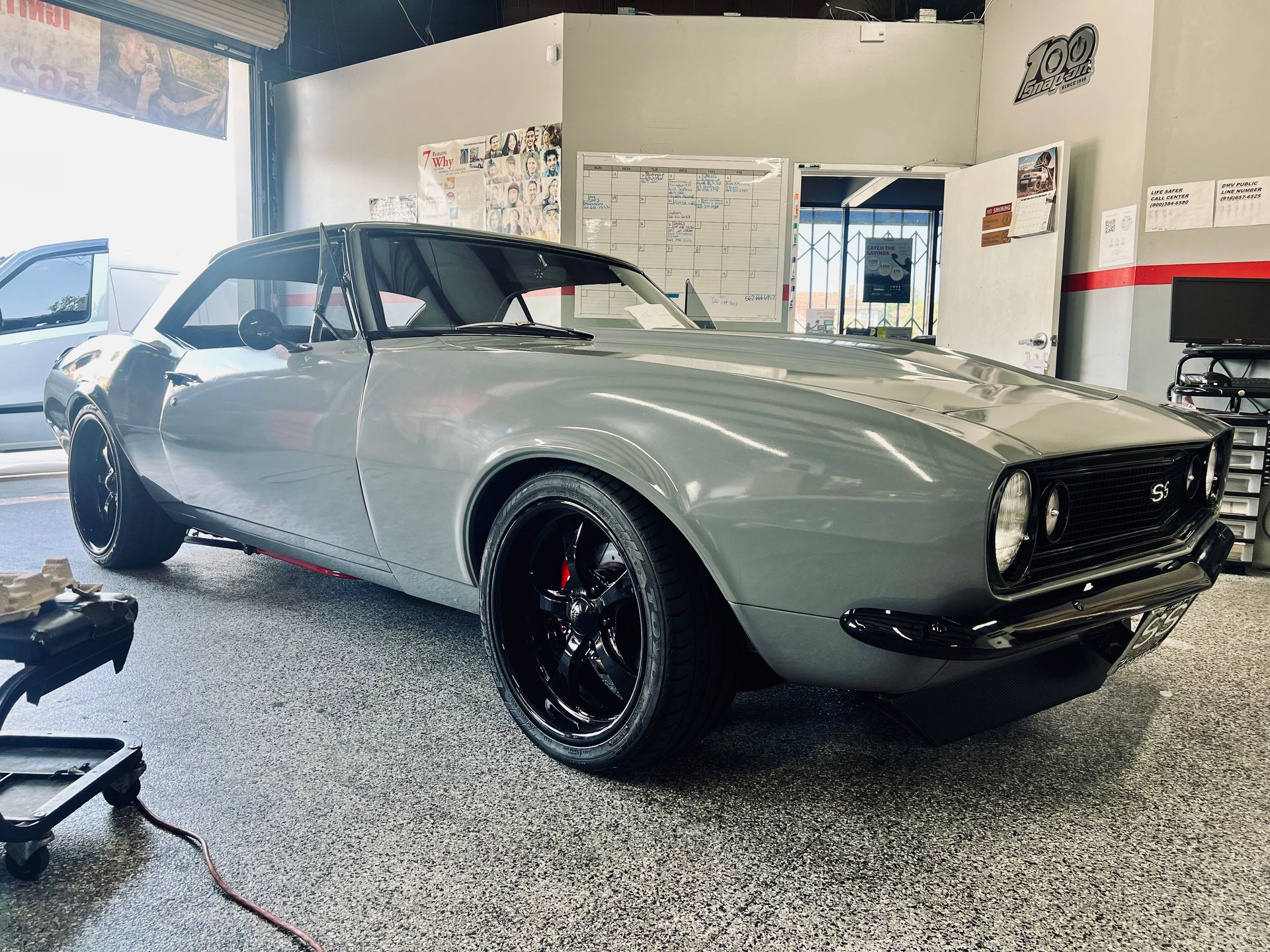 A gray car is parked in a garage.