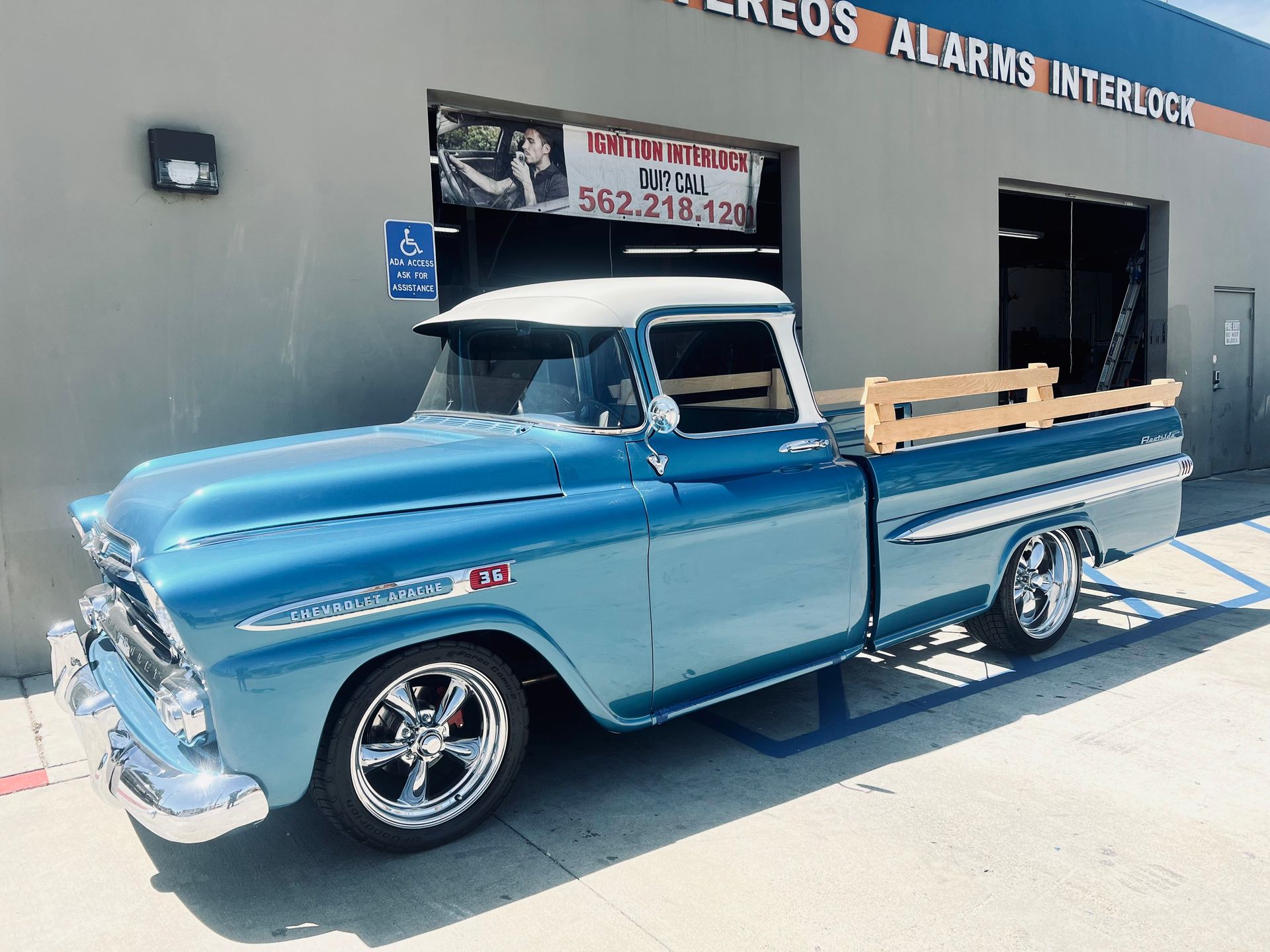 A blue truck is parked in front of a building.