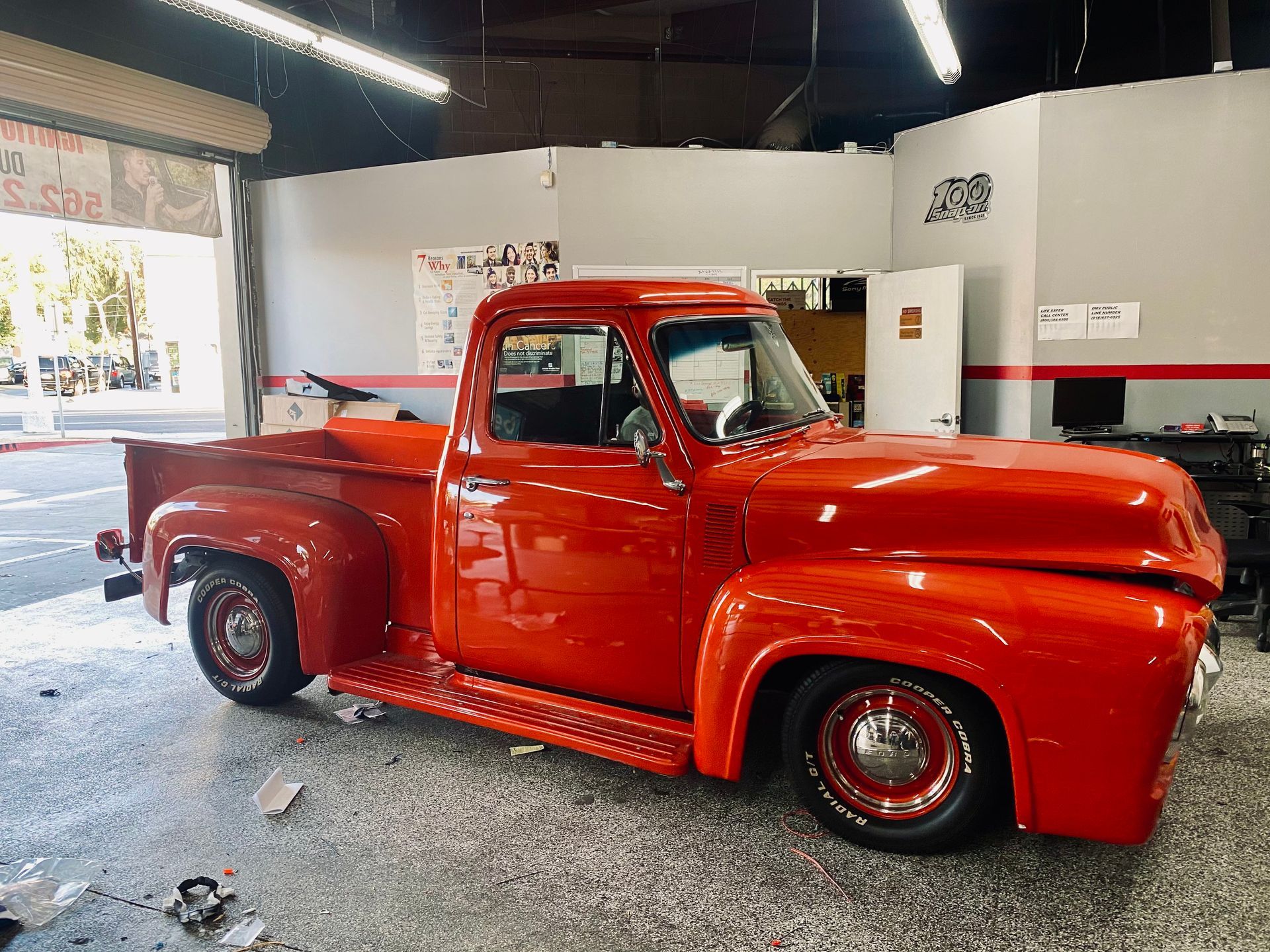 A red pickup truck is parked in a garage.