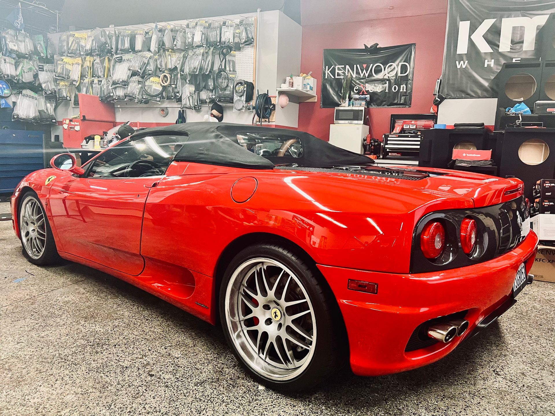 A red sports car is parked in a garage.
