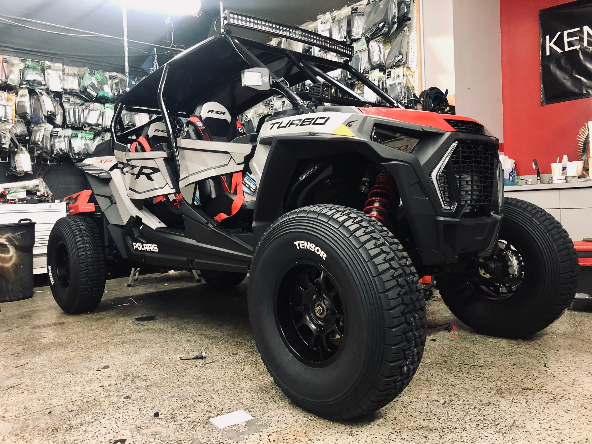 A red and white atv is parked in a garage.