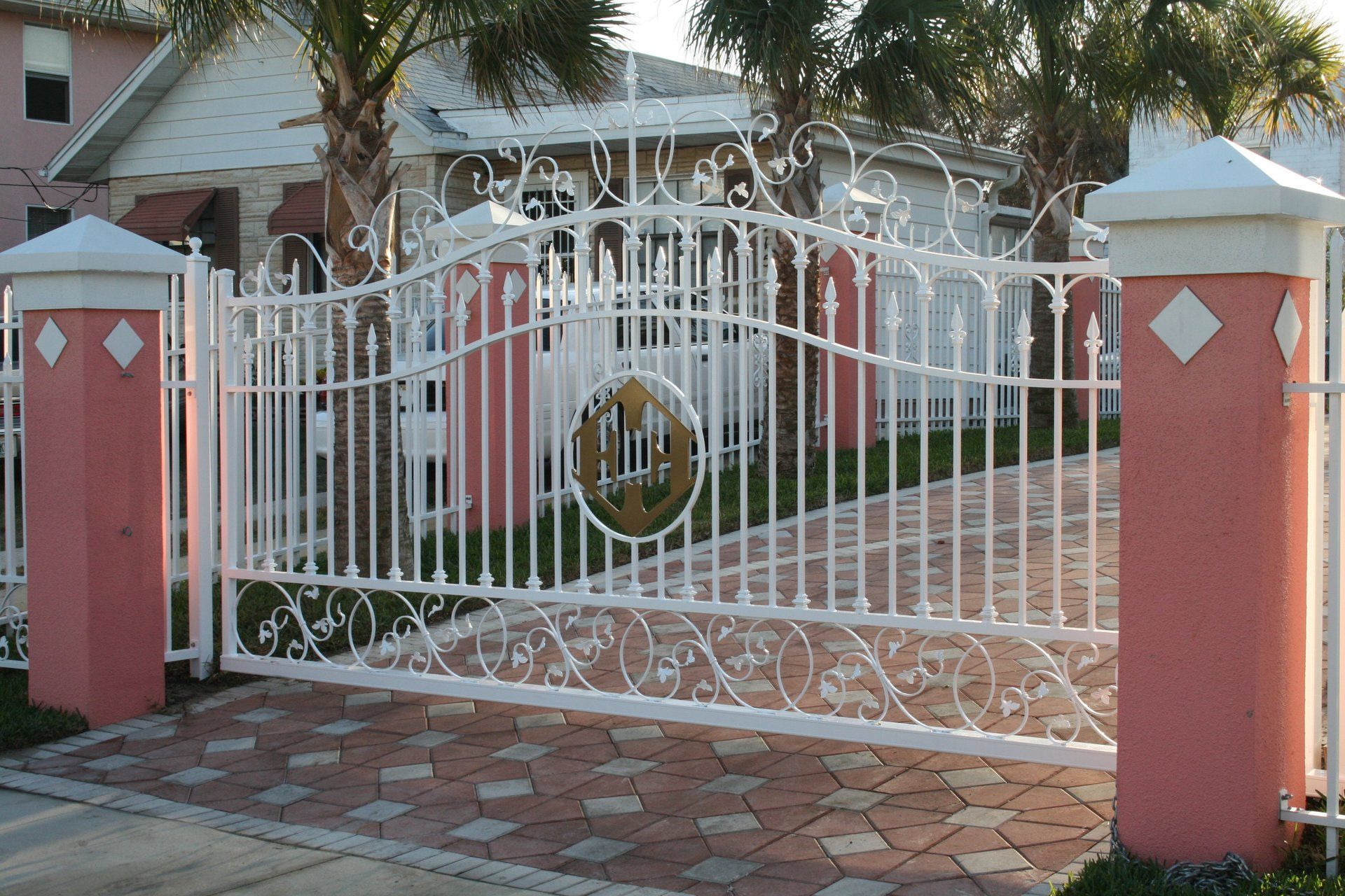 Custom ornamental single aluminum drive gate with marine grade castings; oak pattern with spear points and initial logo