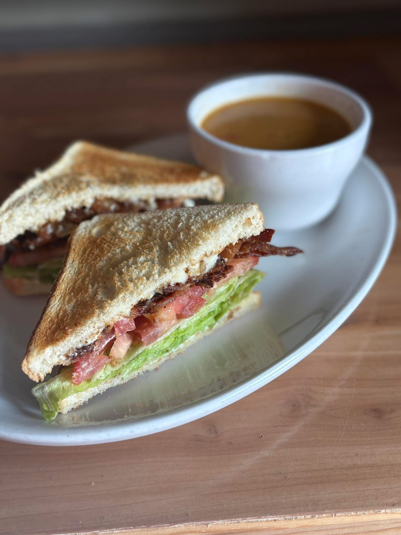 A club sandwich and a cup of coffee on a plate.