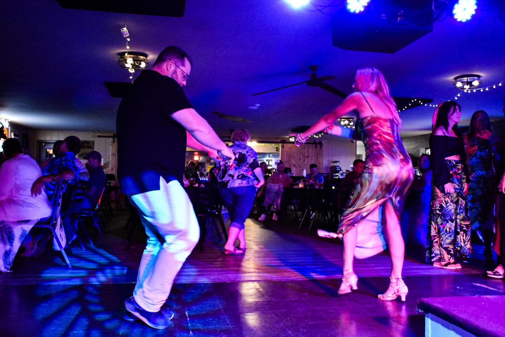 A man and a woman are dancing on a dance floor in a club.