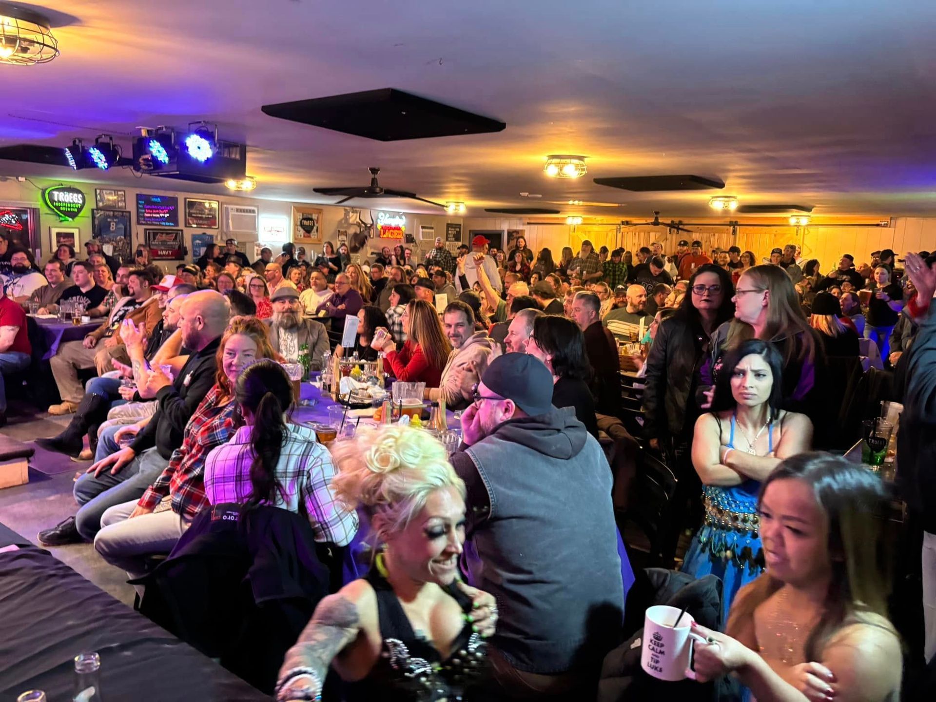 A large group of people are sitting in a room watching a show.