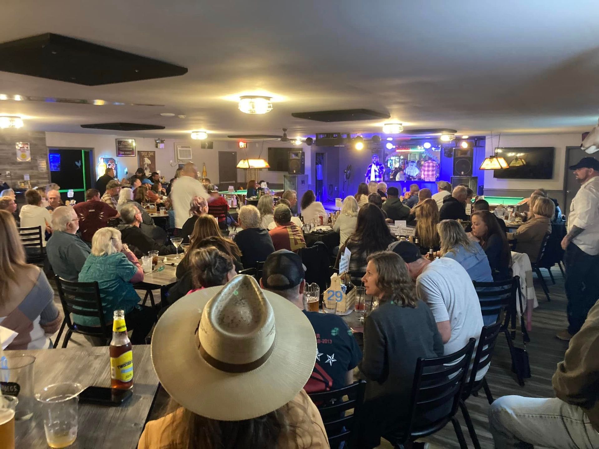 A large group of people are sitting at tables in a restaurant.