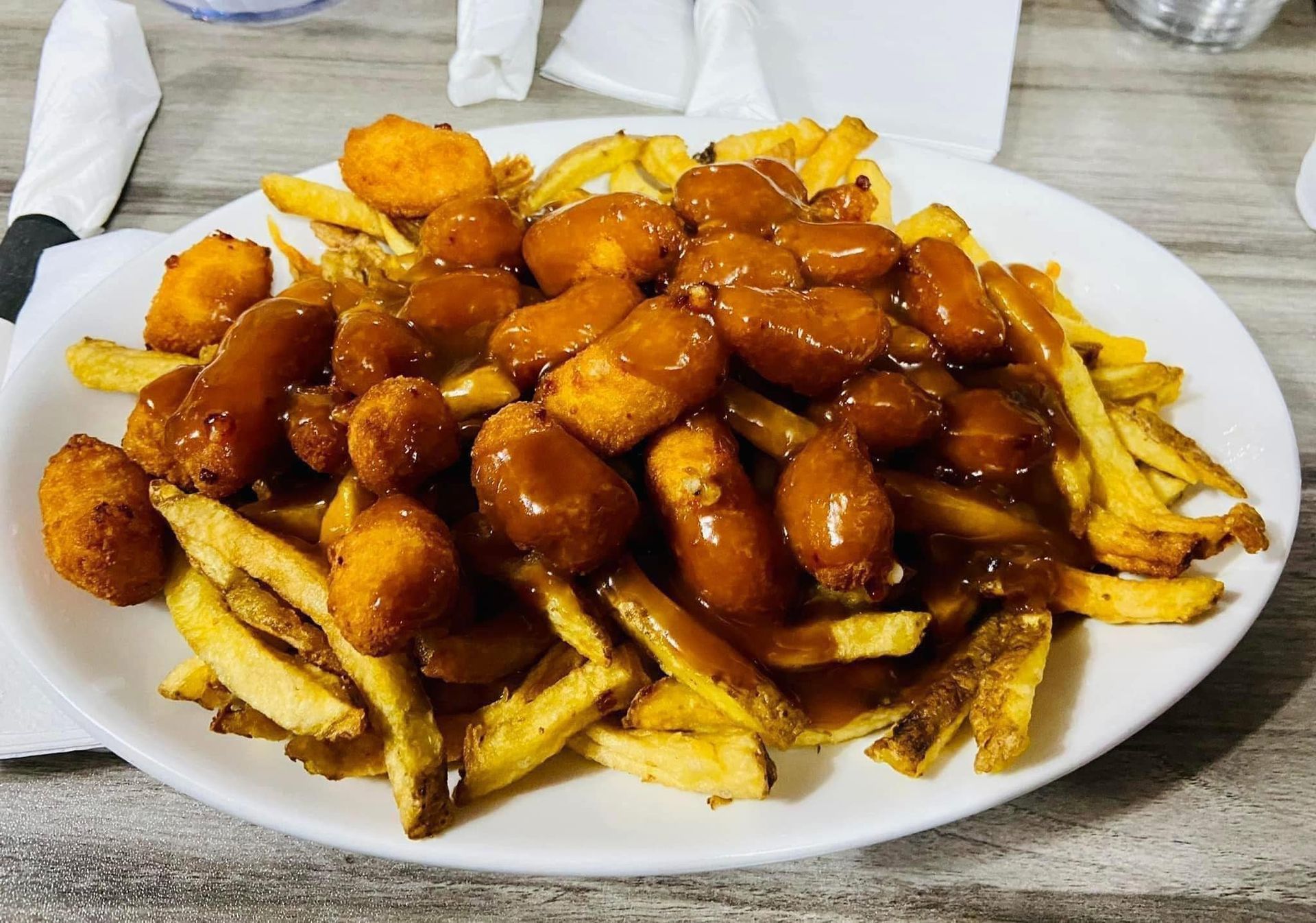 A plate of food with french fries and chicken on a table.