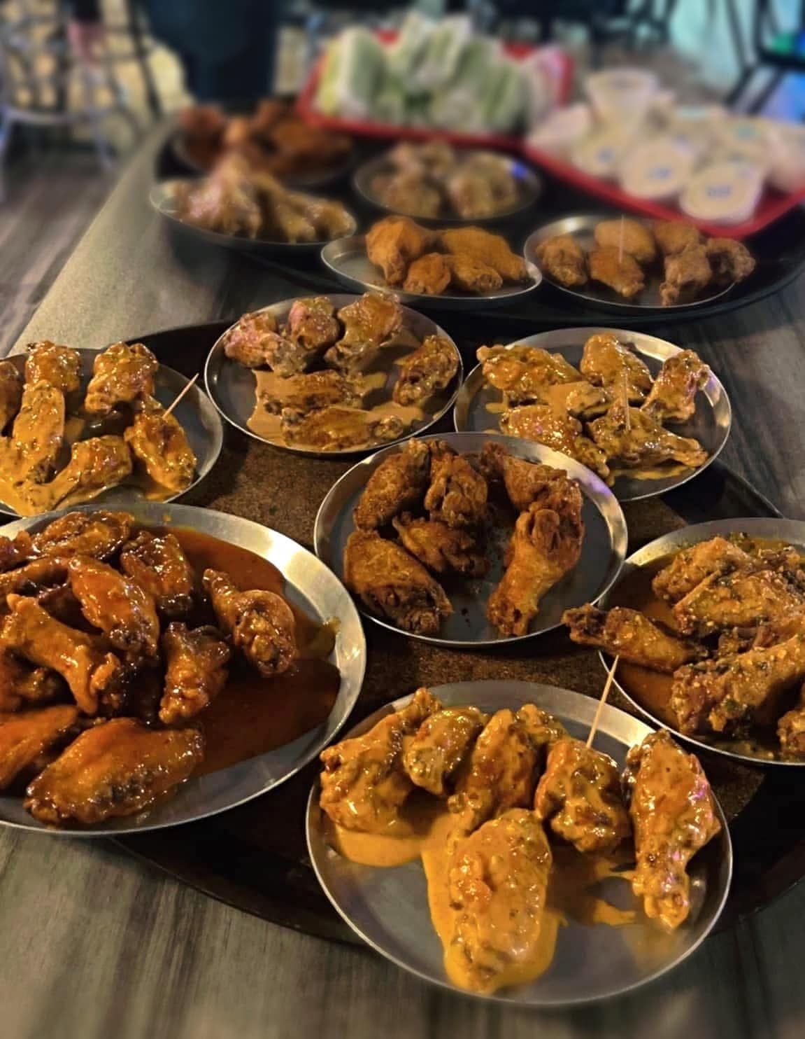 There are many different types of chicken wings on the plates.