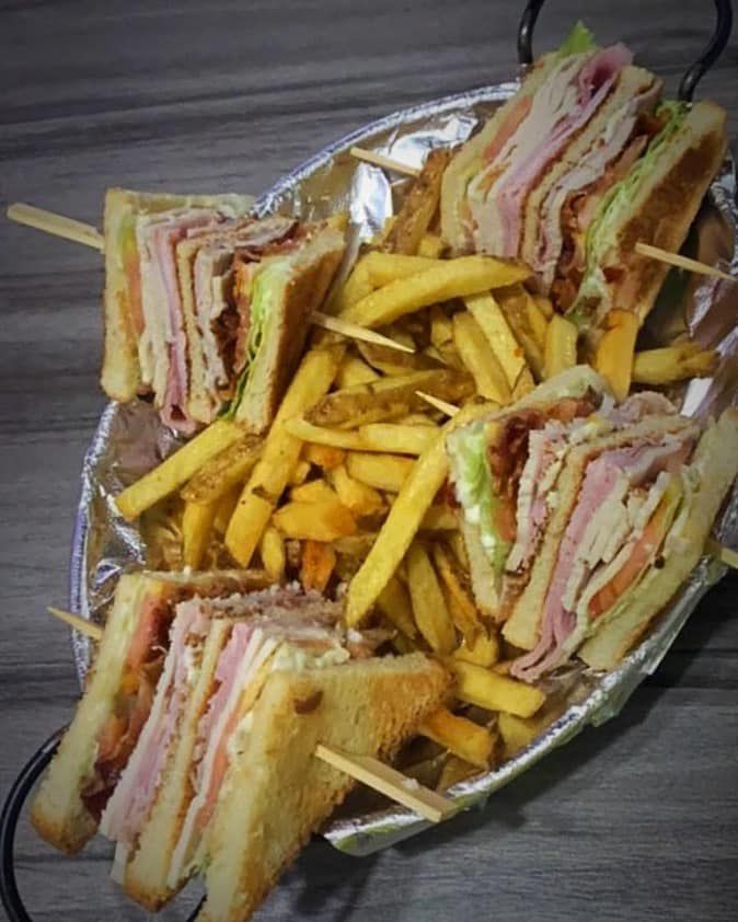 A plate of sandwiches and french fries on a table