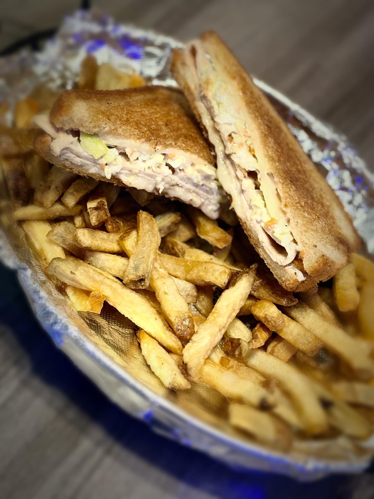 A sandwich and french fries in a bowl on a table.