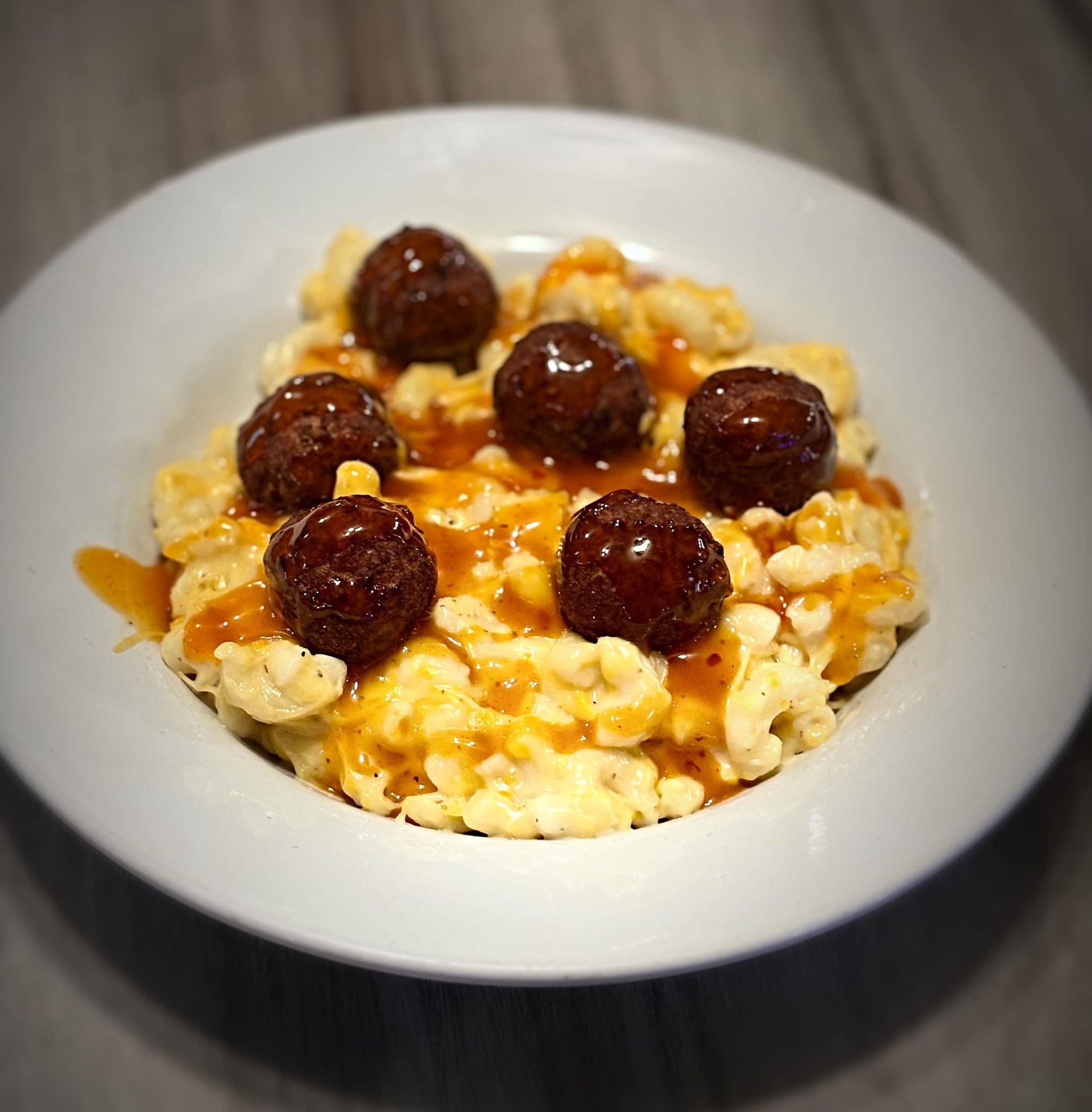 A white plate topped with macaroni and cheese and meatballs