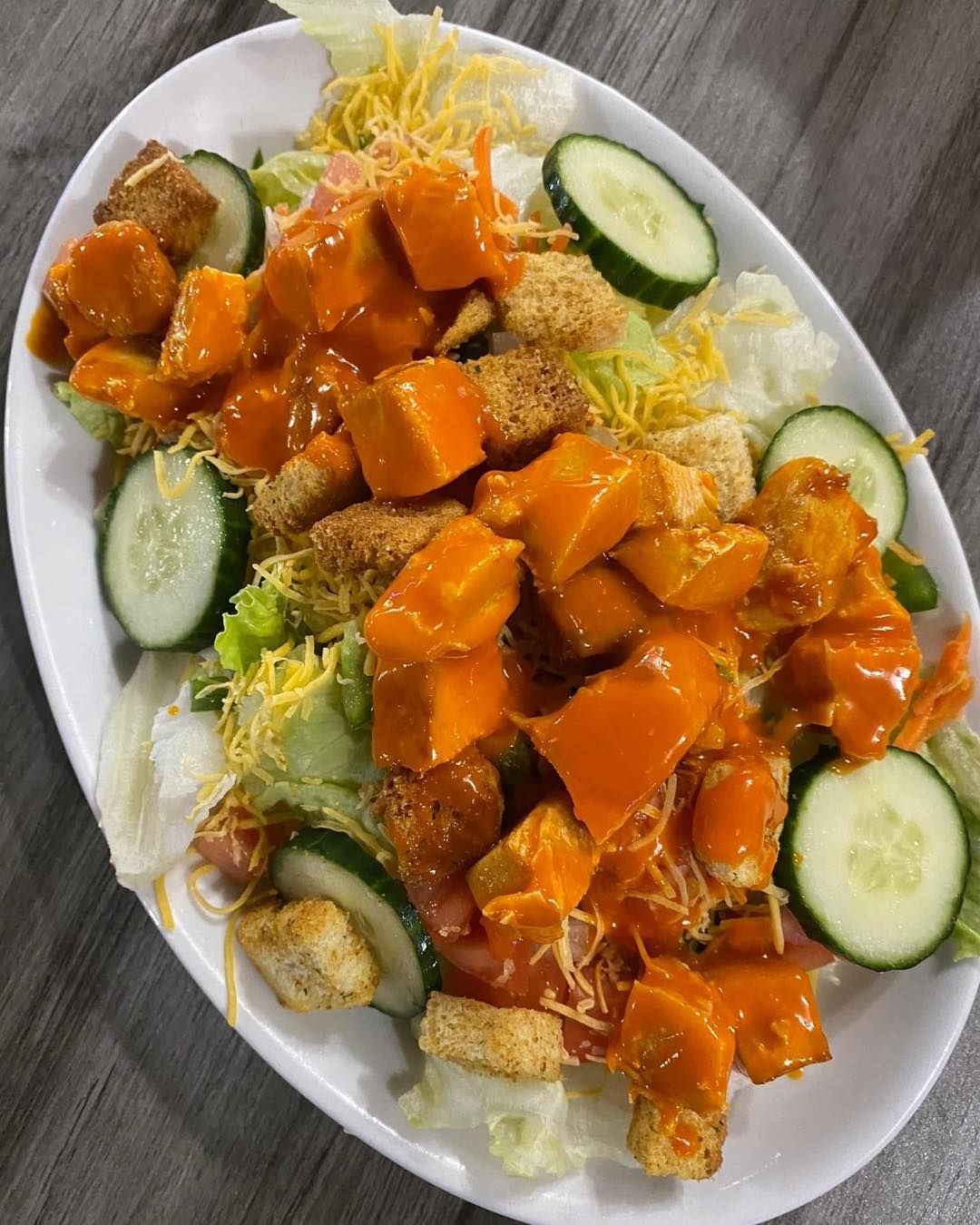 A close up of a salad on a plate on a table.