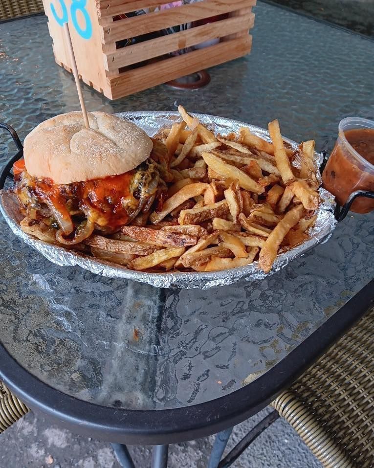 A hamburger and french fries on a plate on a table.