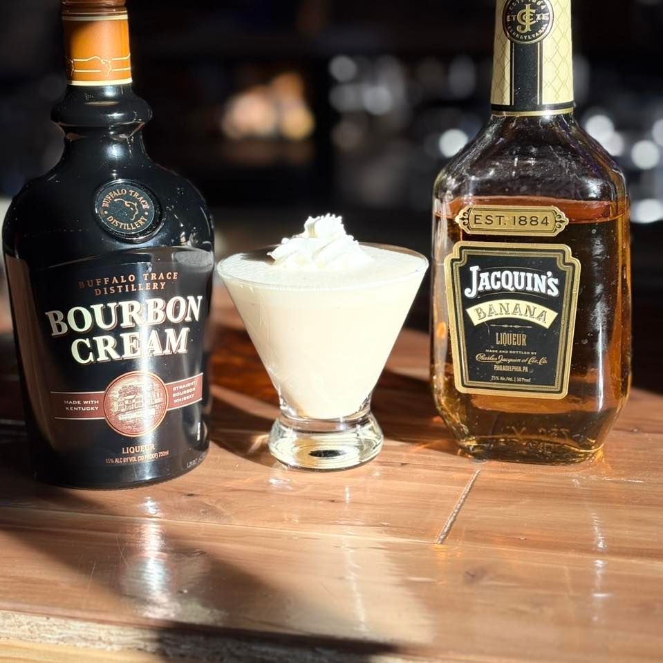 A bottle of bourbon cream next to a bottle of jacquins banana liqueur