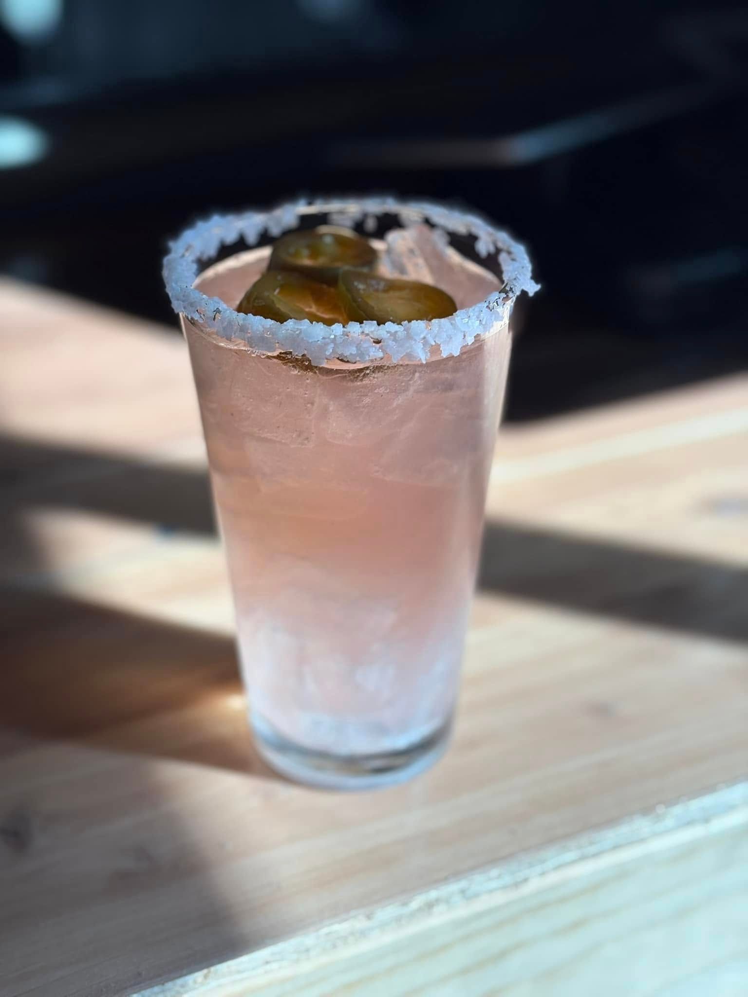 A close up of a drink in a glass on a table.