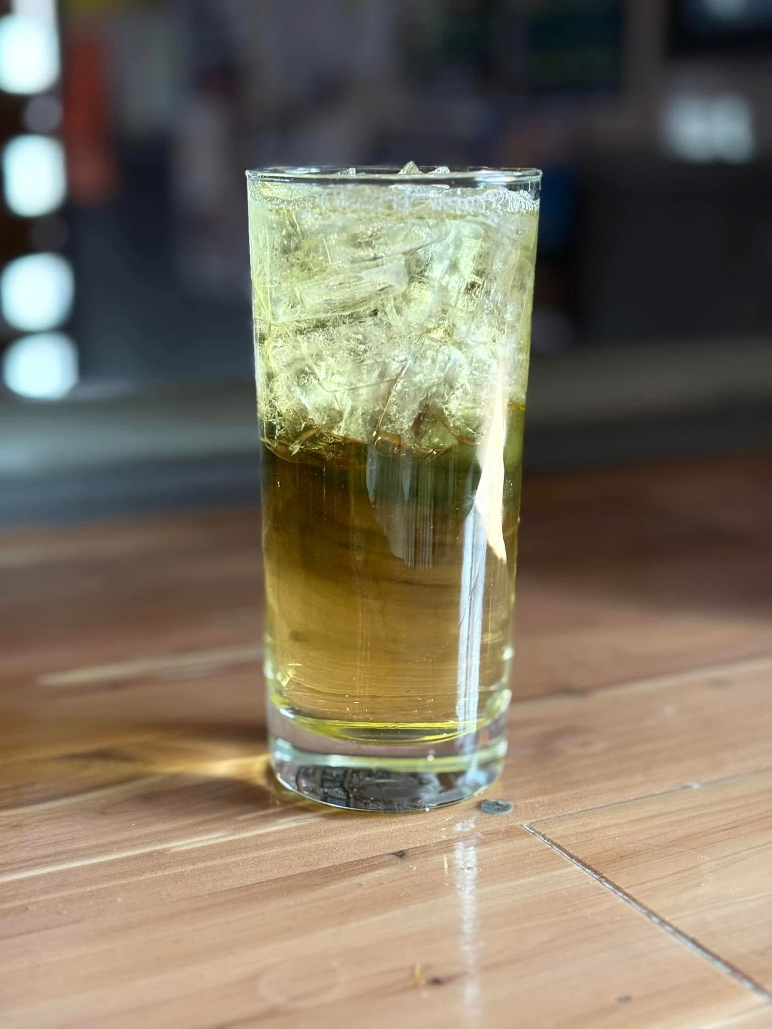 A glass of beer is sitting on a wooden table.
