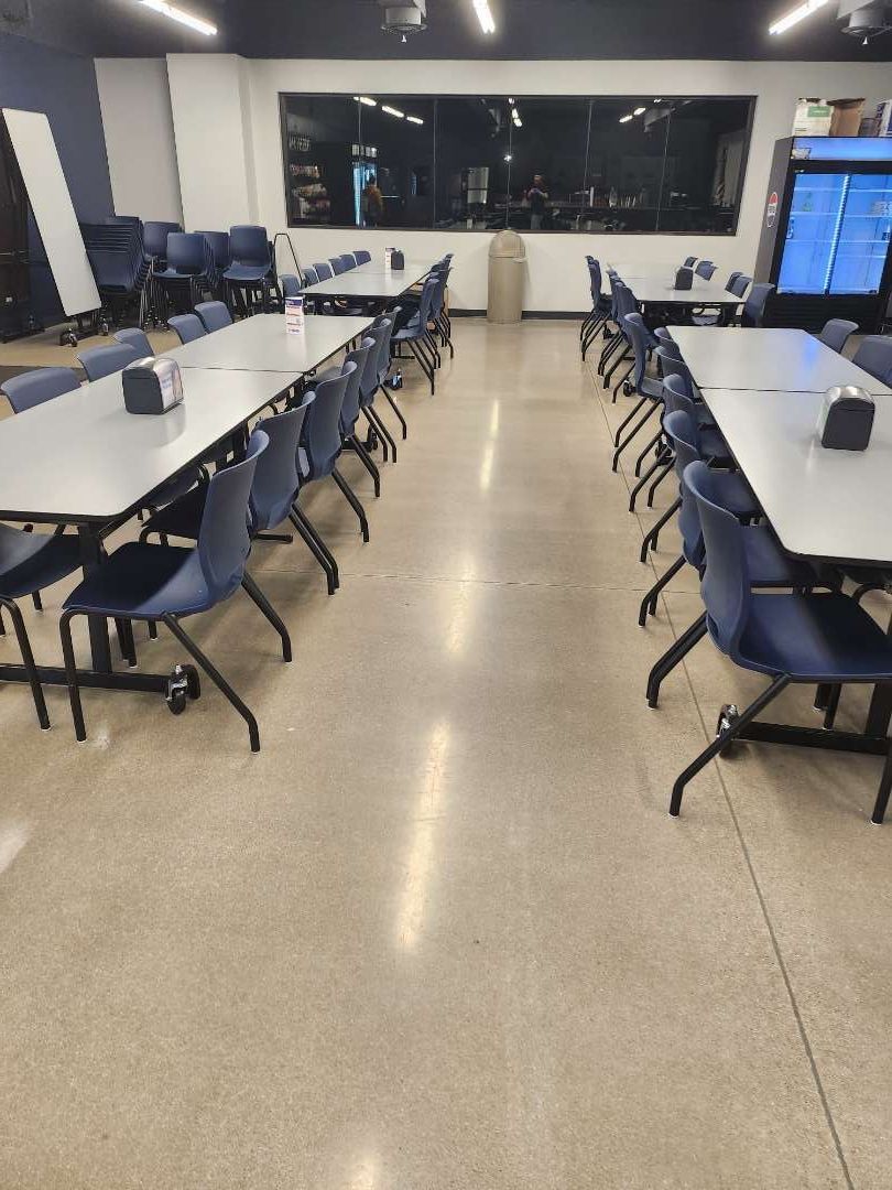 A long room with tables and chairs in it.