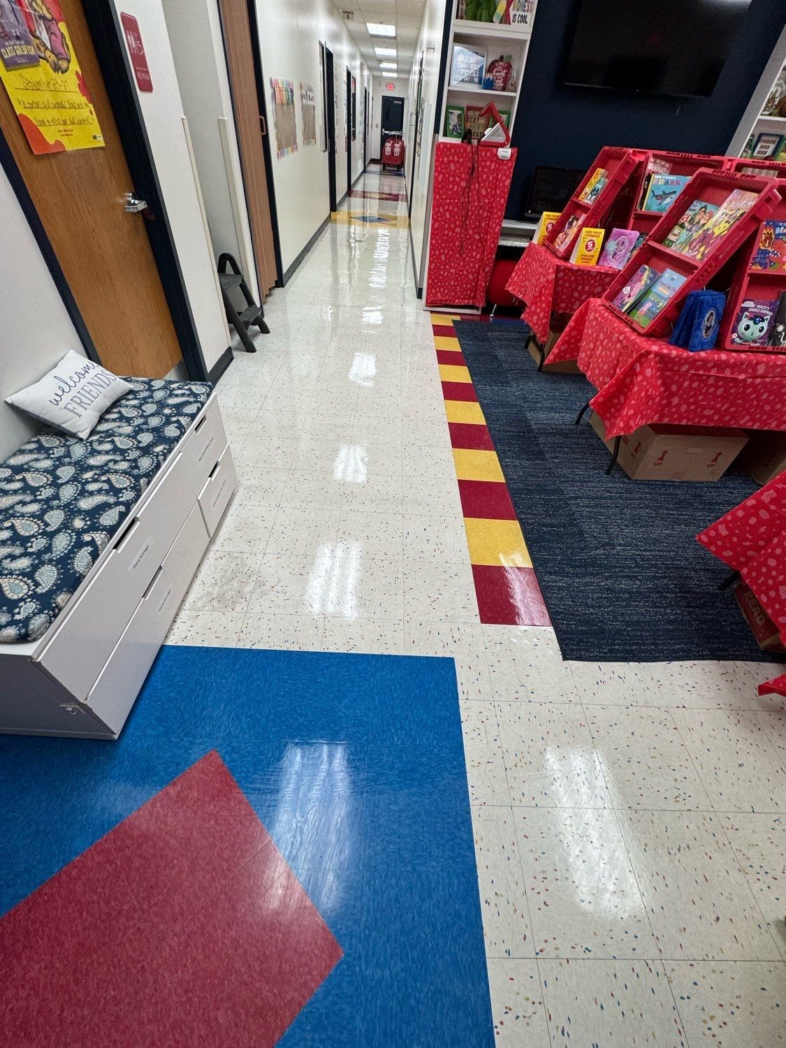 A long hallway filled with bookshelves and a bench.