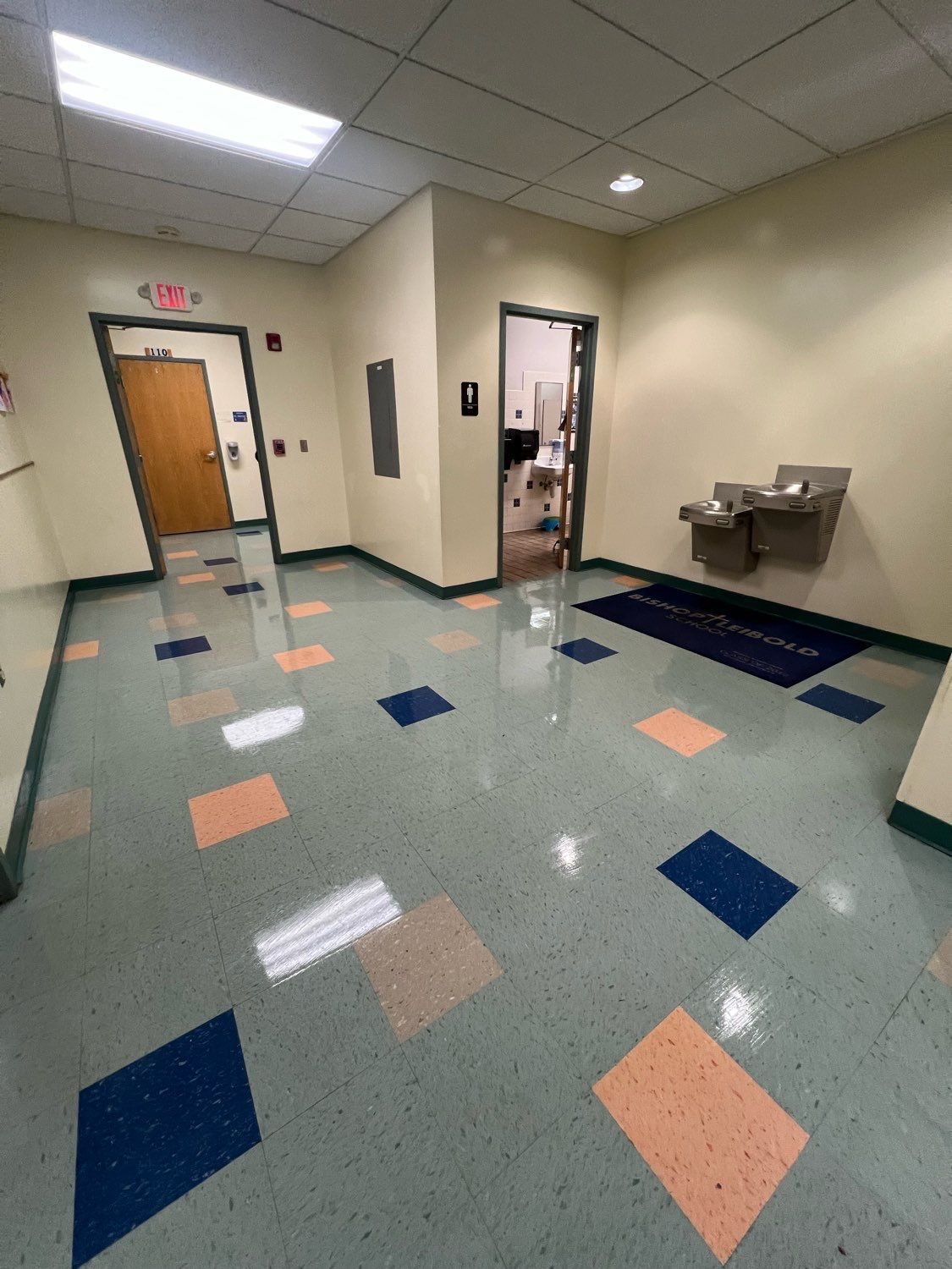 A hallway with a water fountain in the middle of it.