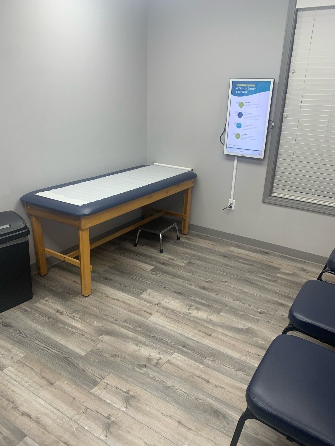 A doctor 's office with a table and chairs.