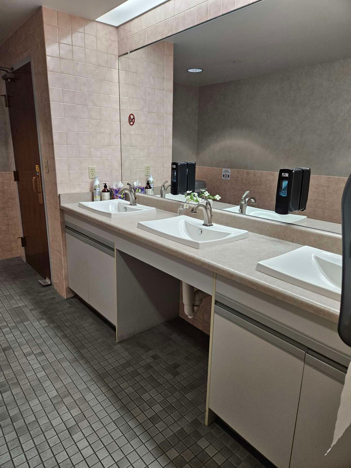 A bathroom with two sinks and a large mirror.