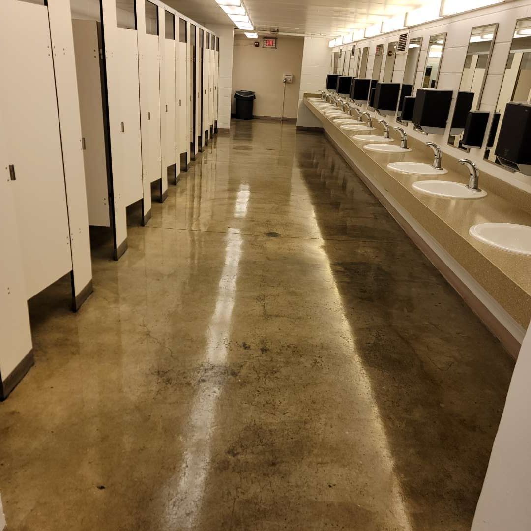 A bathroom with a lot of sinks and cubicles.