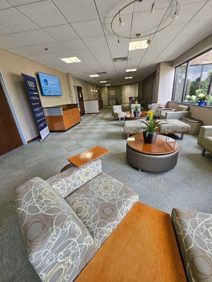 There are many chairs and tables in the room.