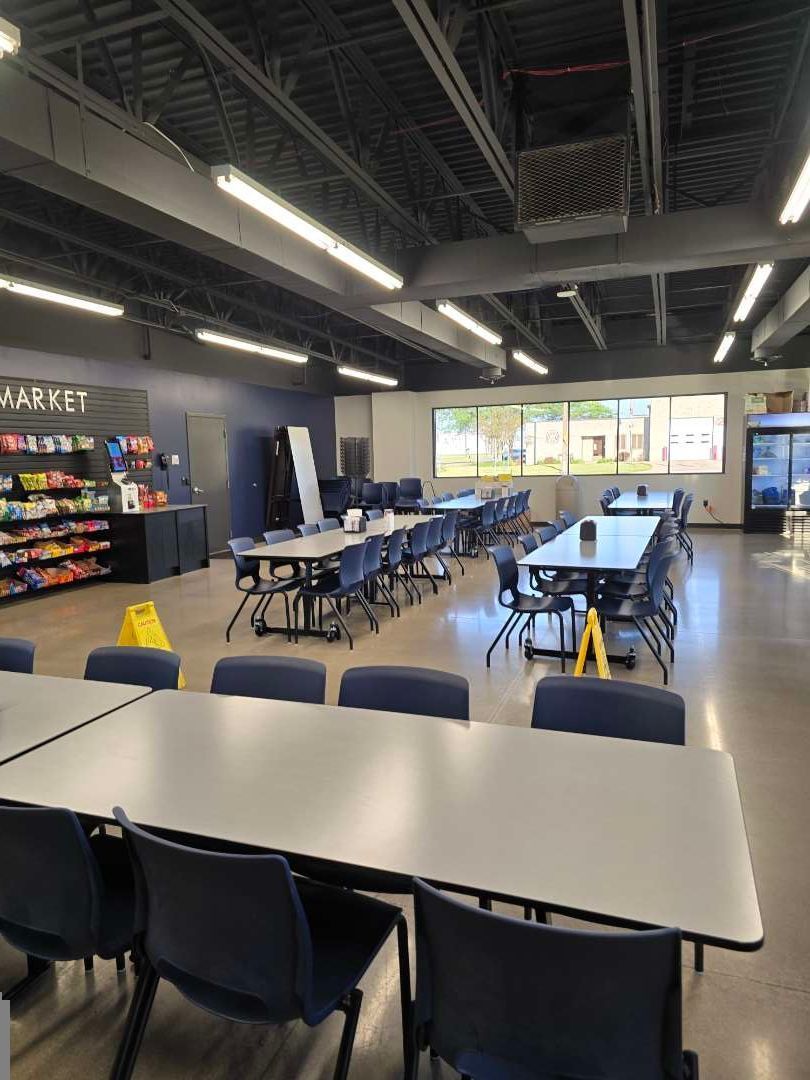 A large room with tables and chairs in it.