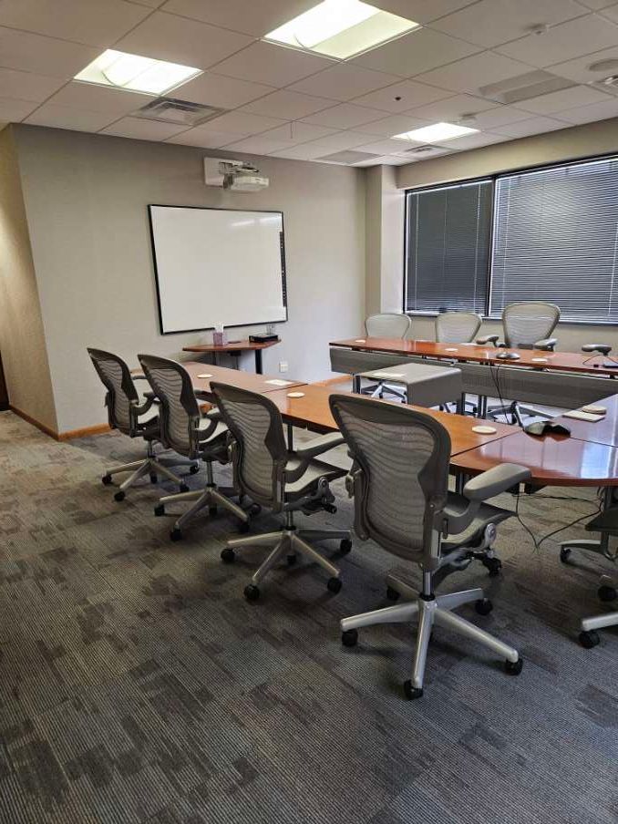 A conference room with a long table and chairs.