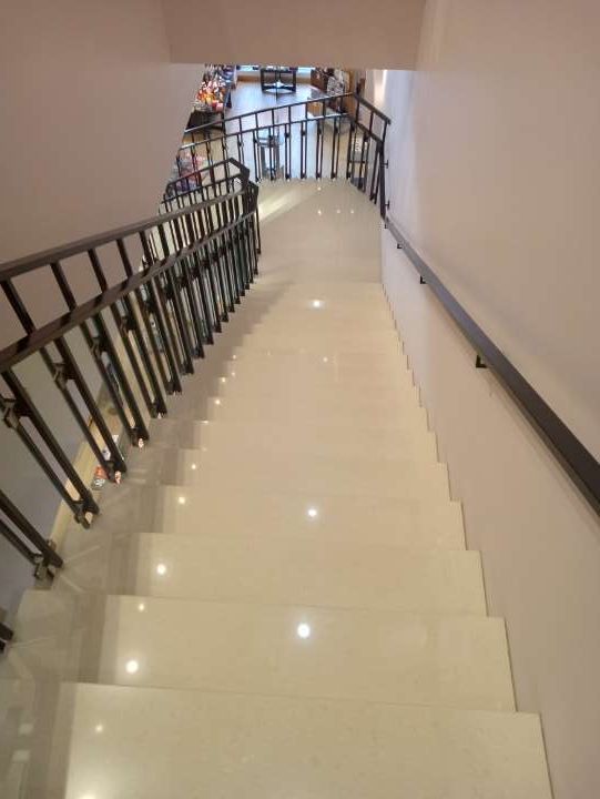 A set of stairs with a railing going up to the second floor.