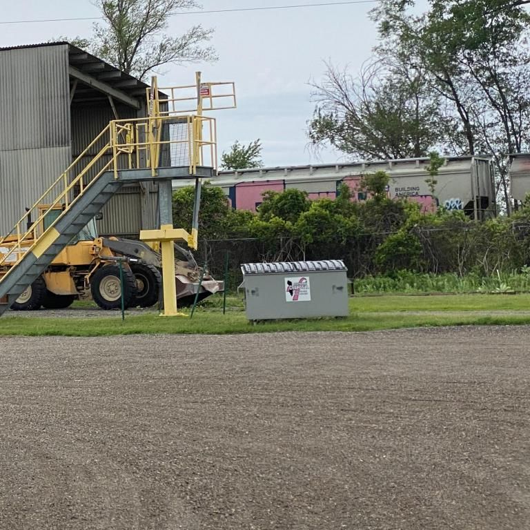 a yellow tractor is parked in front of a building with stairs