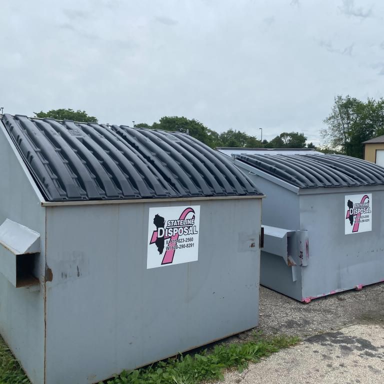 a couple of dumpsters with a breast cancer awareness logo on them