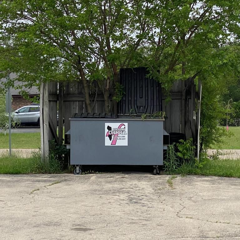 a dumpster with a breast cancer awareness logo on it is in a parking lot