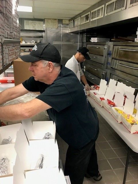 A man wearing a ny hat is working in a kitchen