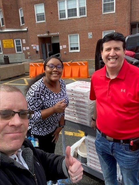 A man in a red shirt is giving a thumbs up