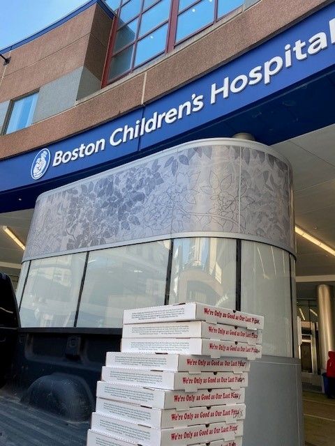 A stack of pizza boxes outside of boston children 's hospital