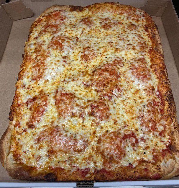 A large pizza is sitting in a cardboard box.