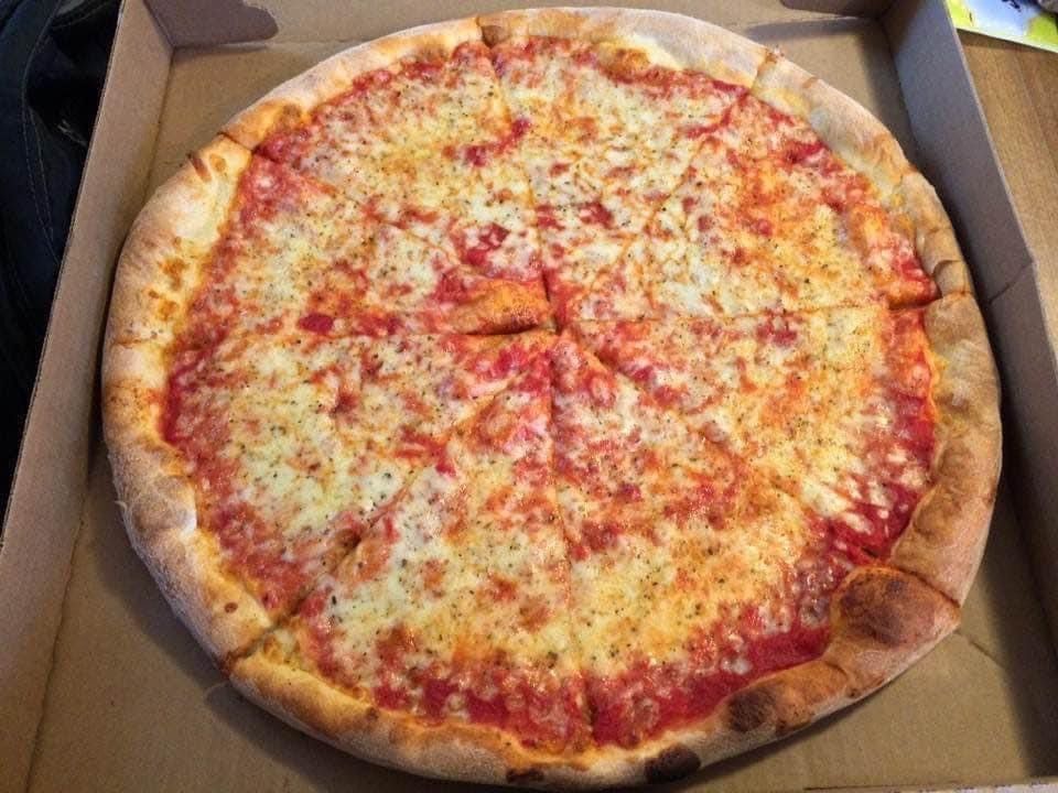 A pizza is sitting in a cardboard box on a table.