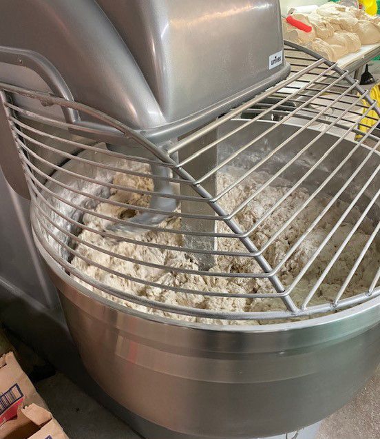 A mixer filled with flour is sitting next to some boxes